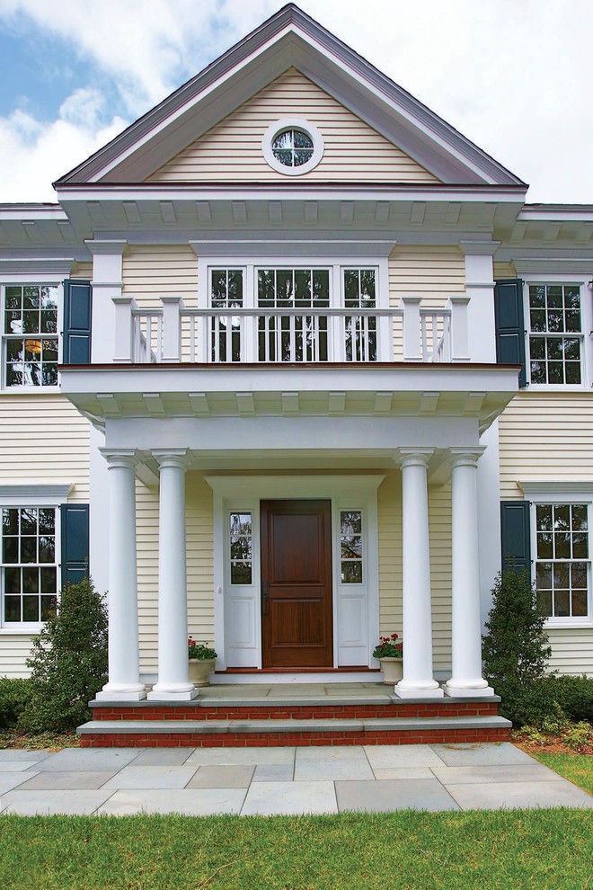Large elegant yellow two-story wood exterior home photo in Boston with a shingle roof