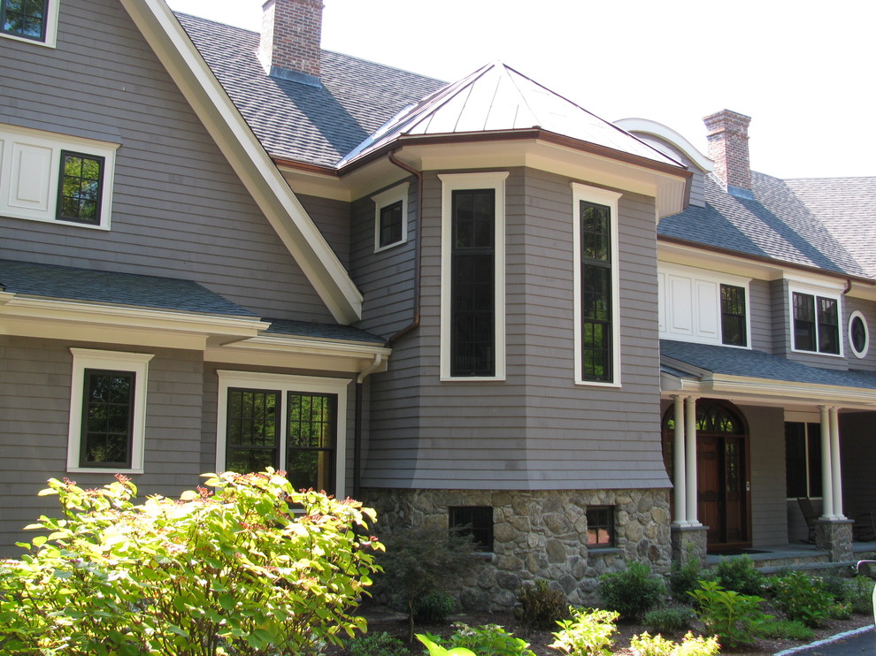 Cette photo montre une très grande façade de maison grise chic en bois à deux étages et plus avec un toit à quatre pans et un toit en shingle.