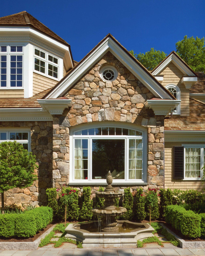 Large traditional beige two-story stone exterior home idea in Boston with a shingle roof