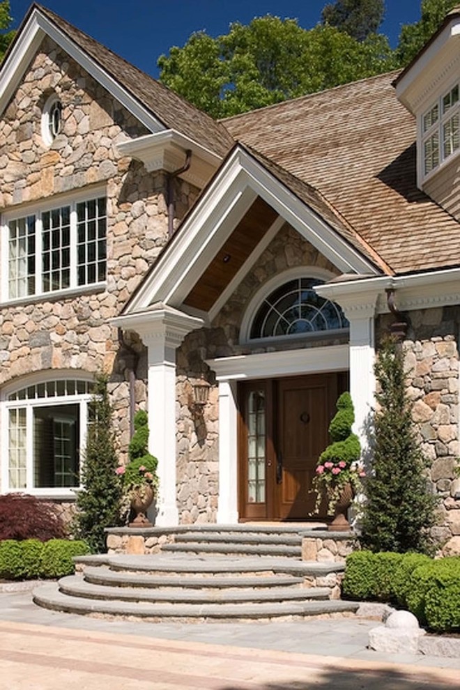 Inspiration for a large timeless beige two-story stone exterior home remodel in Boston with a shingle roof