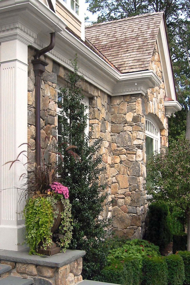 Inspiration pour une grande façade de maison beige traditionnelle en bois à un étage avec un toit à deux pans et un toit en shingle.