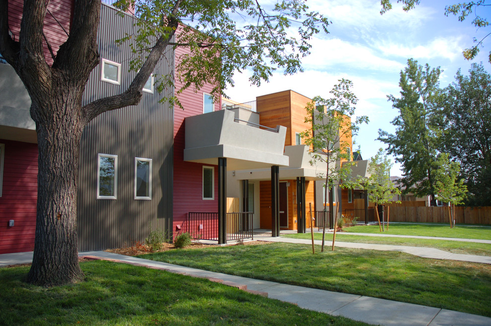 Cette image montre une grande façade de maison rouge design à un étage avec un revêtement mixte.