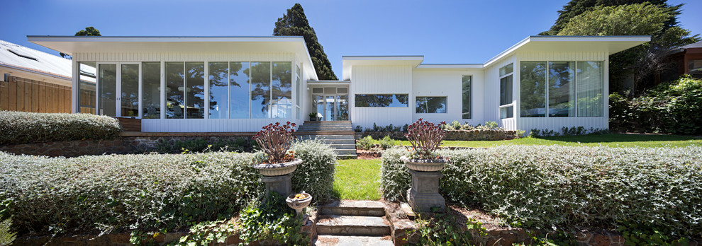 Einstöckiges Modernes Haus mit weißer Fassadenfarbe und Flachdach in Melbourne