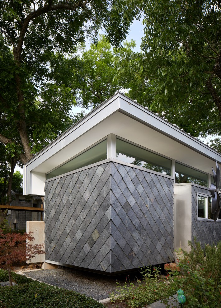 Idée de décoration pour une petite façade de maison grise minimaliste en pierre de plain-pied avec un toit en appentis et un toit en métal.