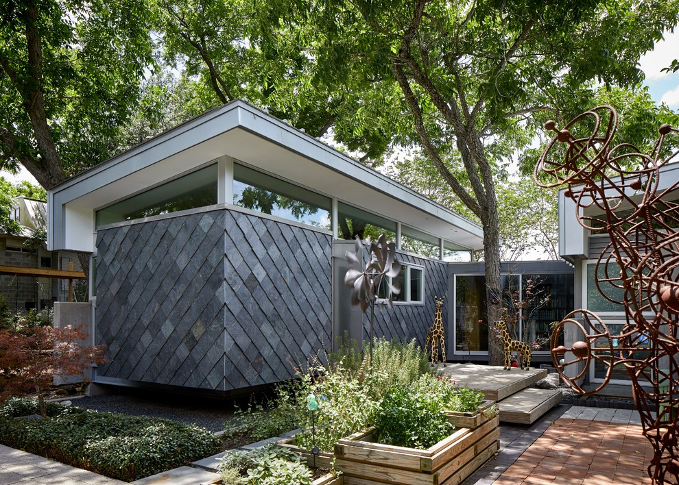 Kleines, Einstöckiges Modernes Einfamilienhaus mit Steinfassade, grauer Fassadenfarbe, Pultdach und Blechdach in Houston