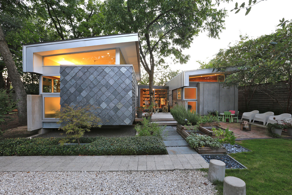 Aménagement d'une façade de maison grise contemporaine de plain-pied avec un revêtement mixte et un toit en appentis.