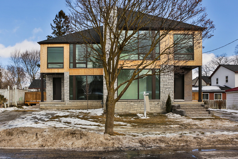 Photo of a small and gey classic two floor semi-detached house in Toronto with stone cladding, a hip roof and a shingle roof.