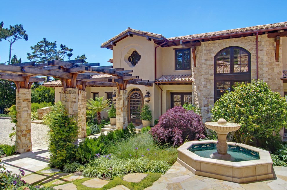 Large and beige mediterranean two floor house exterior in San Luis Obispo with stone cladding.