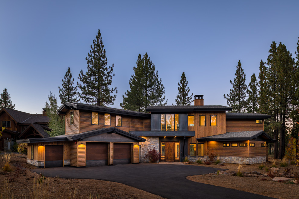 Cette photo montre une très grande façade de maison marron moderne en bois à un étage avec un toit à deux pans.