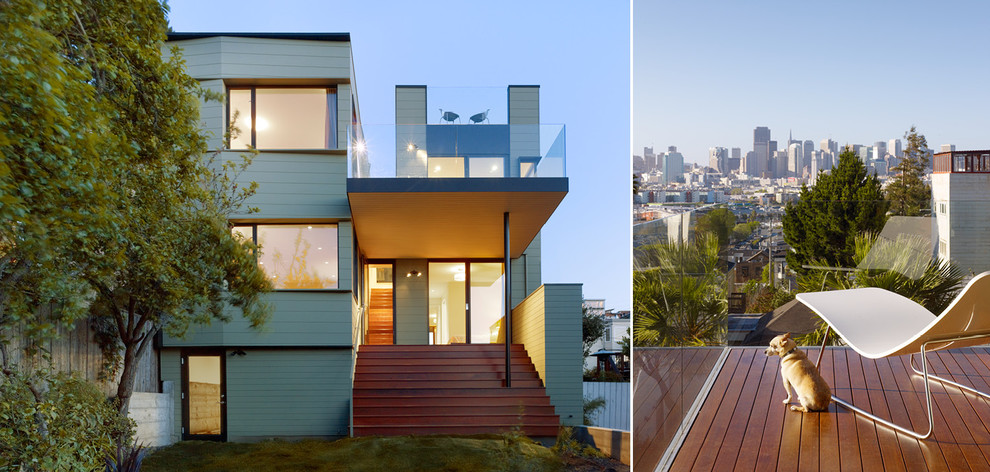 Cette photo montre une grande façade de maison verte moderne en bois à deux étages et plus avec un toit plat.