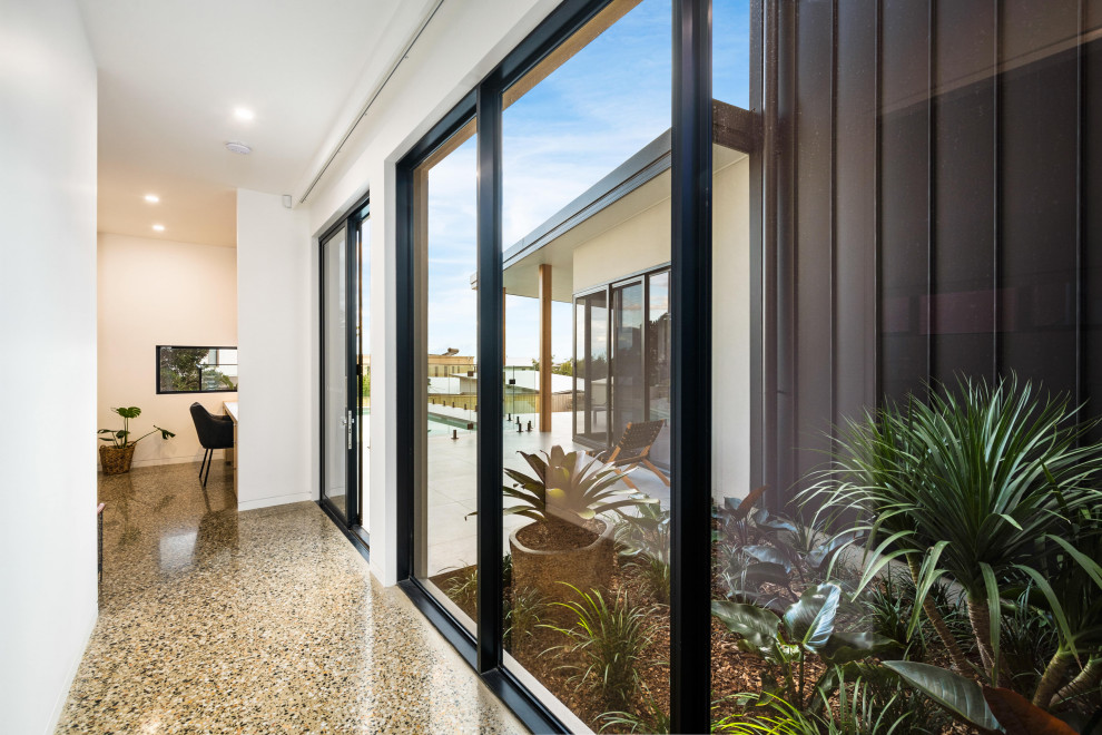 Großes, Zweistöckiges Modernes Einfamilienhaus mit Mix-Fassade, schwarzer Fassadenfarbe, Flachdach und Blechdach in Wollongong