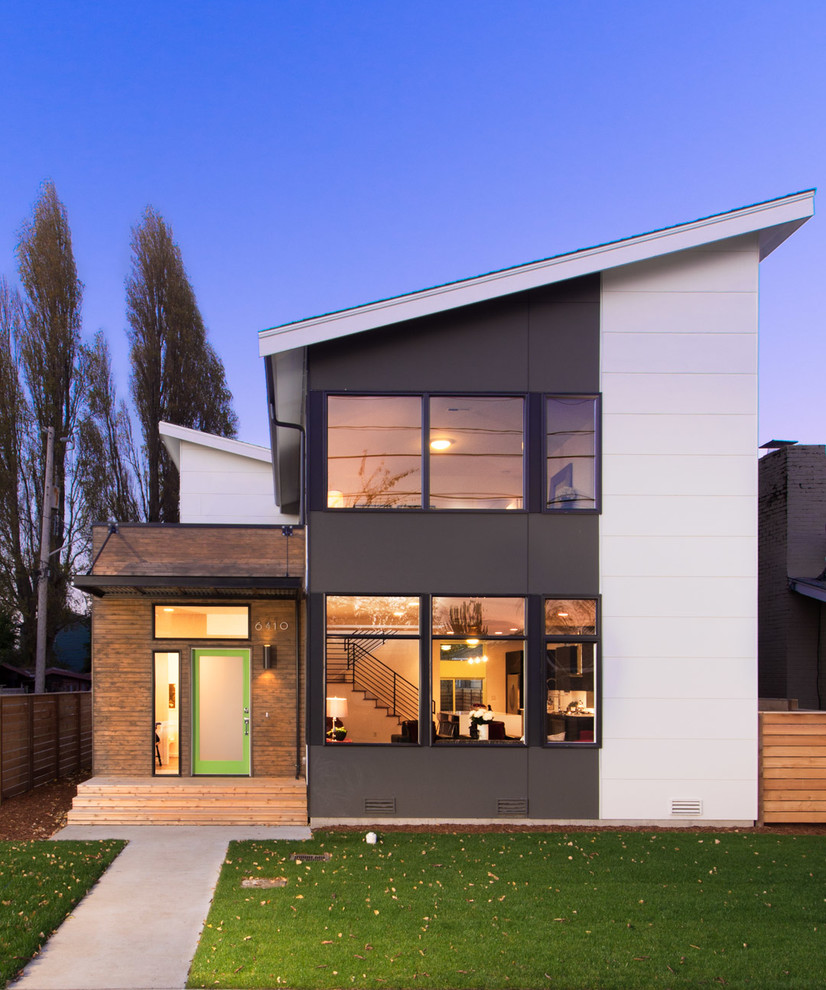 Réalisation d'une façade de maison design à un étage avec un revêtement mixte et un toit en appentis.