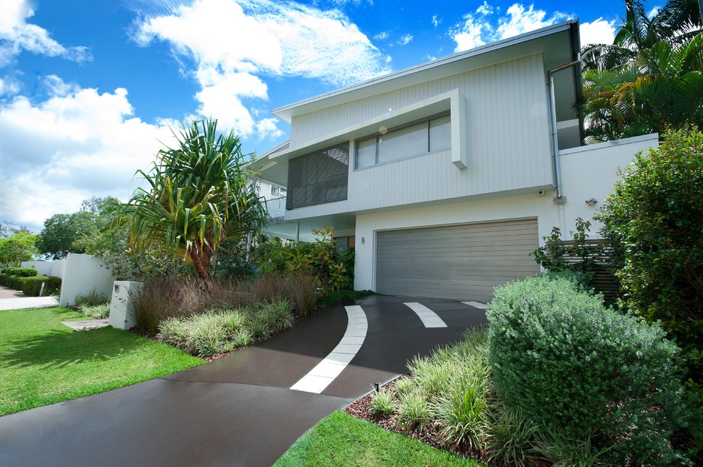 This is an example of a large and white beach style two floor house exterior in Sunshine Coast with mixed cladding.