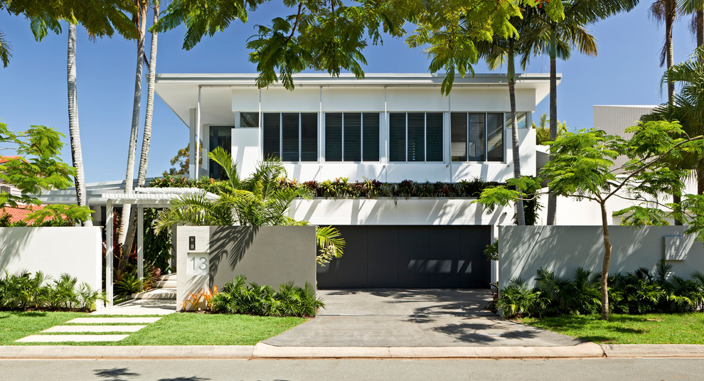 Inspiration för ett tropiskt vitt hus, med två våningar