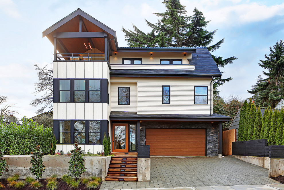 This is an example of a large and white scandinavian detached house in Seattle with three floors.