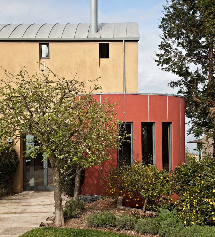 Imagen de fachada de casa beige contemporánea grande de dos plantas con revestimiento de estuco y tejado de metal