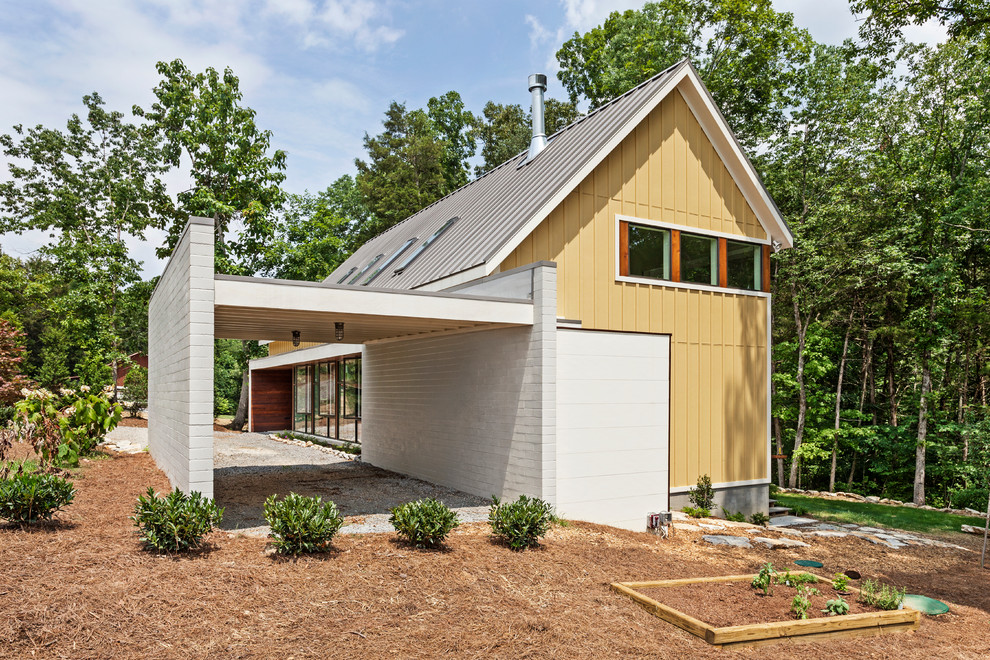他の地域にあるコンテンポラリースタイルのおしゃれな家の外観 (黄色い外壁) の写真