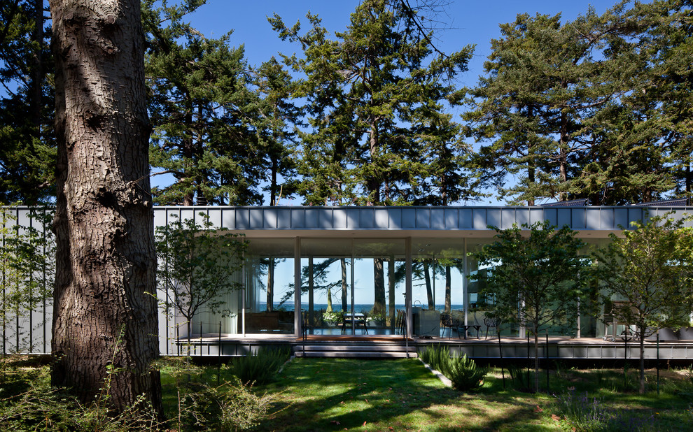 Ispirazione per la facciata di una casa grigia moderna a un piano di medie dimensioni con rivestimento in metallo e tetto piano