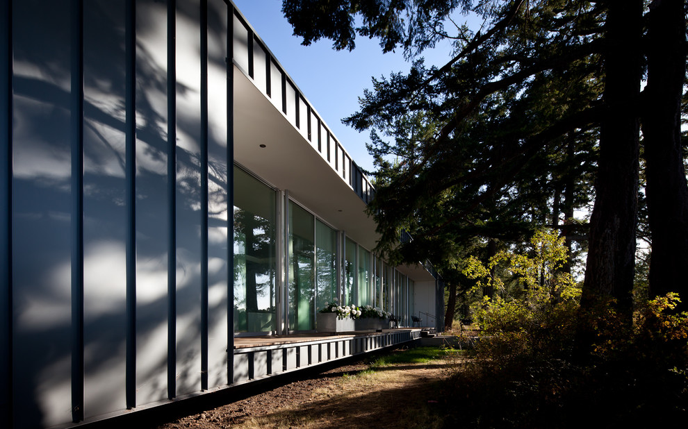 Пример оригинального дизайна: одноэтажный, серый дом среднего размера в стиле модернизм с облицовкой из металла и плоской крышей