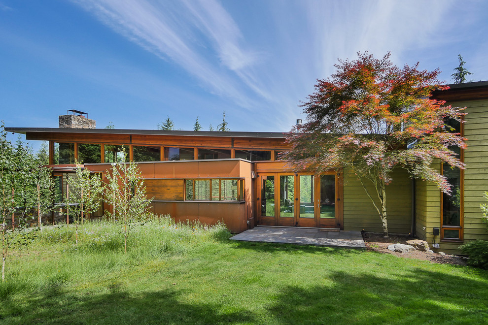 Источник вдохновения для домашнего уюта: двухэтажный, зеленый дом среднего размера в стиле модернизм с комбинированной облицовкой и односкатной крышей