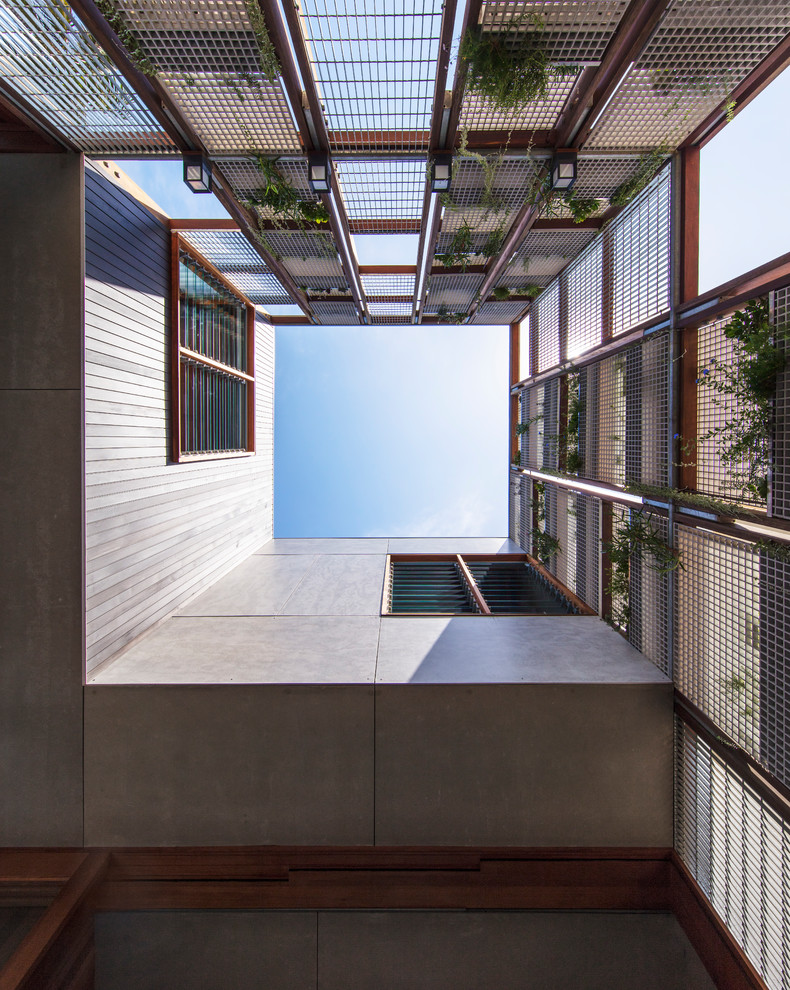 Foto de fachada de casa moderna de dos plantas con revestimiento de aglomerado de cemento