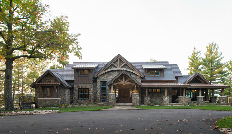 This is an example of an expansive and brown rustic detached house in Minneapolis with three floors, mixed cladding, a pitched roof and a mixed material roof.
