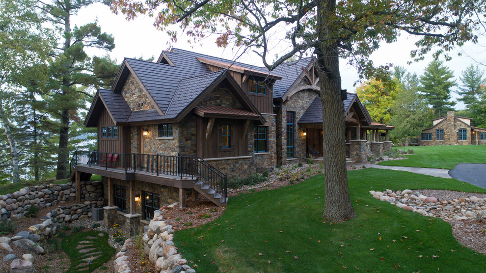 Example of a huge mountain style brown three-story mixed siding exterior home design in Minneapolis with a mixed material roof
