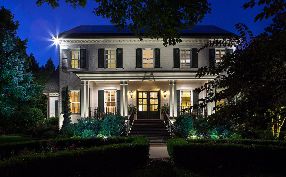 Inspiration for a large timeless white two-story brick exterior home remodel in Raleigh with a shingle roof