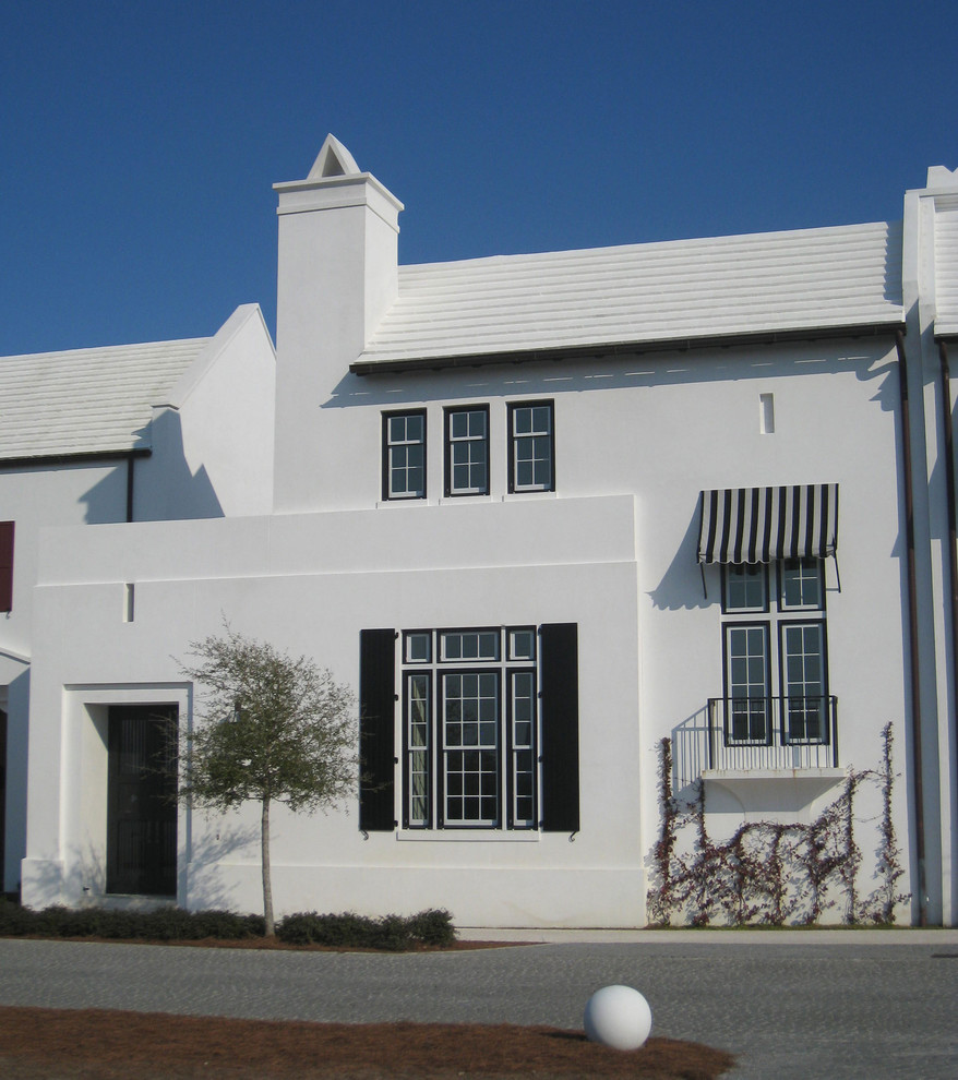 Idee per la facciata di una casa bianca mediterranea a due piani con rivestimento in stucco