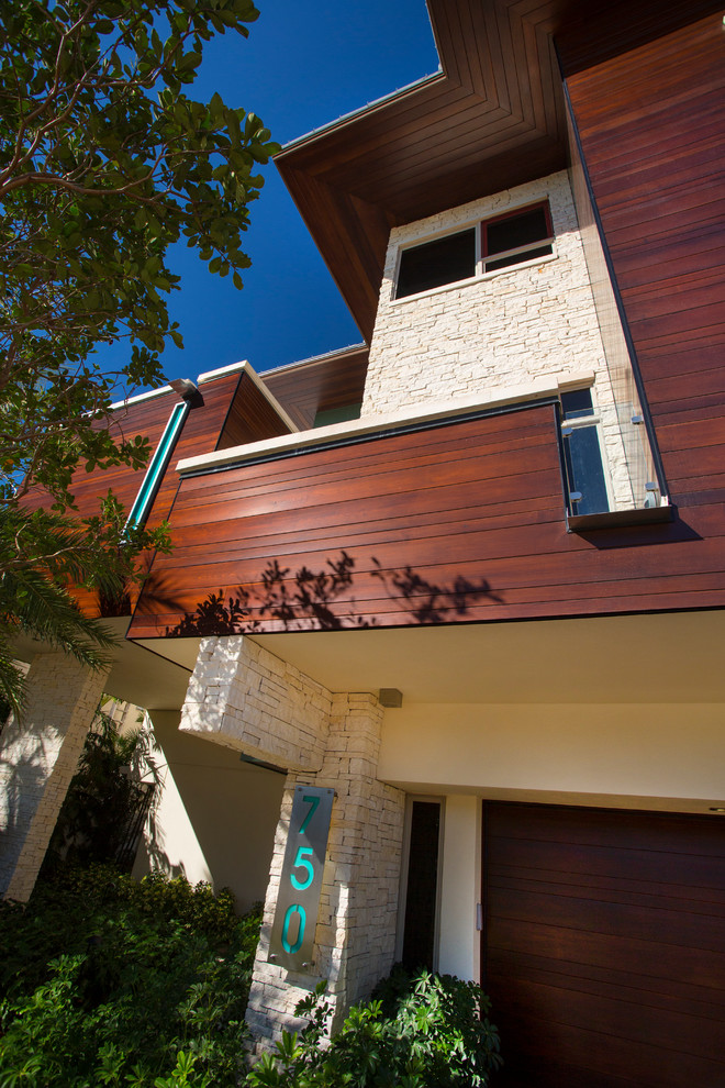 Cette photo montre une petite façade de maison marron moderne en pierre à deux étages et plus avec un toit plat.