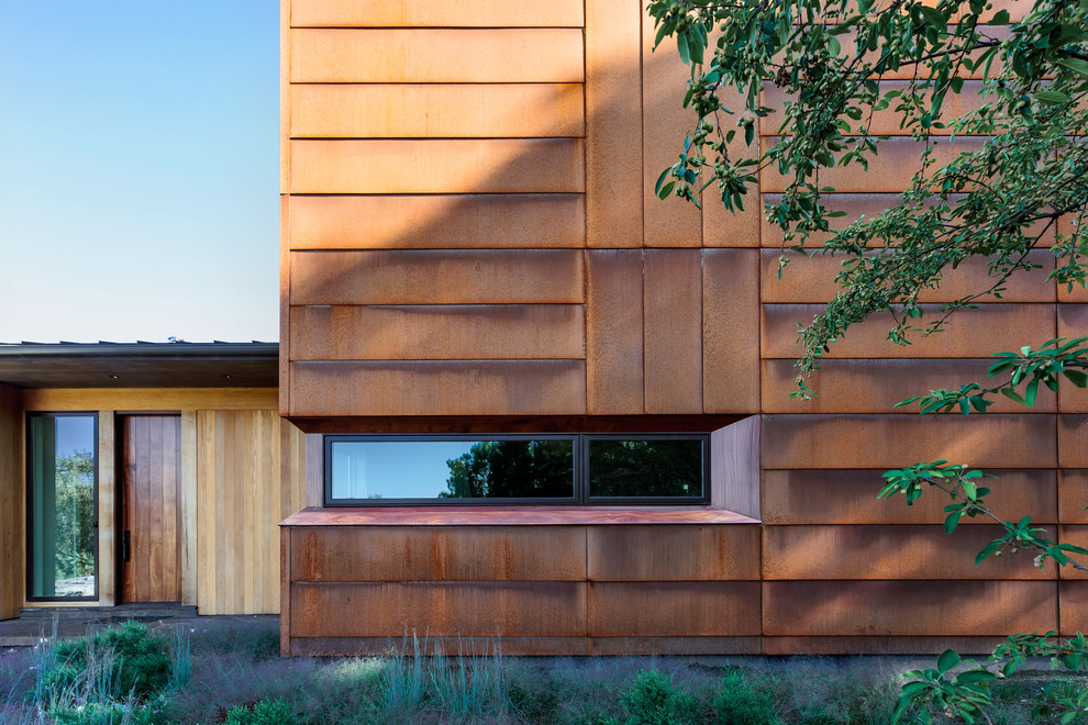 Ispirazione per la facciata di una casa marrone moderna a due piani di medie dimensioni con rivestimento in metallo