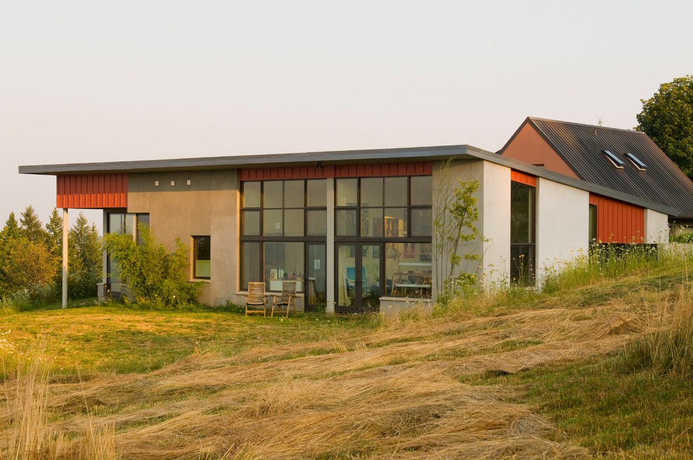 Photo of a large and red contemporary bungalow render house exterior in Portland.