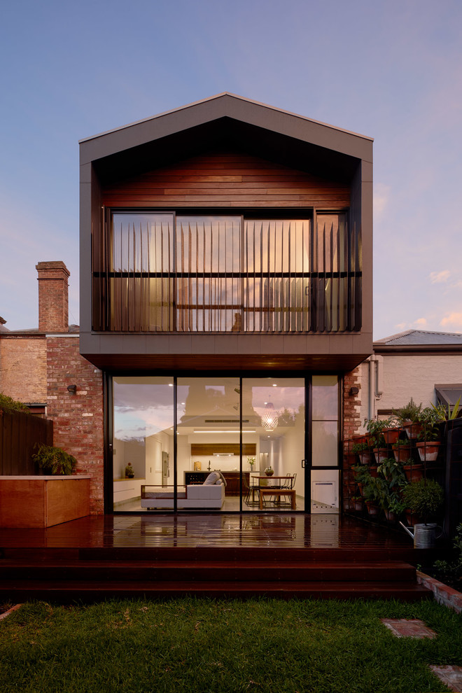 Mittelgroßes, Zweistöckiges Modernes Einfamilienhaus mit Faserzement-Fassade, schwarzer Fassadenfarbe, Satteldach und Blechdach in Melbourne