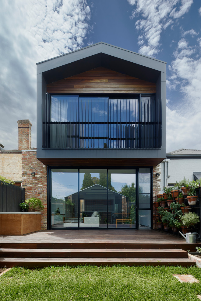 Diseño de fachada de casa negra contemporánea de tamaño medio de dos plantas con revestimiento de aglomerado de cemento, tejado a dos aguas y tejado de metal