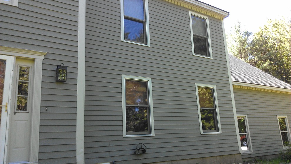 Aménagement d'une façade de maison grise classique en bois de taille moyenne et à un étage avec un toit à deux pans.