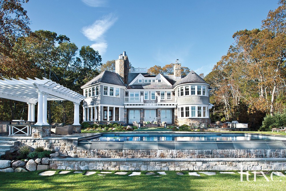 Пример оригинального дизайна: большой, трехэтажный, серый дом в викторианском стиле с комбинированной облицовкой и двускатной крышей