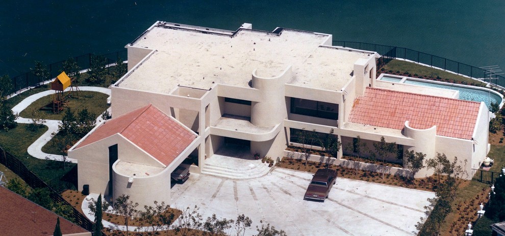 Ispirazione per la facciata di una casa grande grigia moderna a due piani con rivestimento in stucco, tetto piano, copertura in tegole e tetto rosso