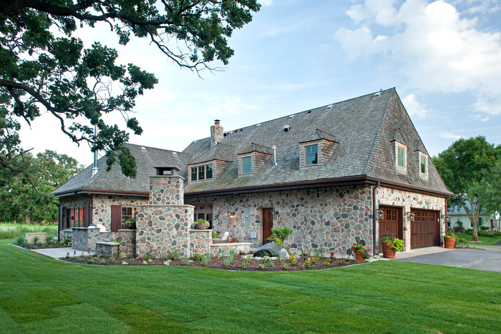 Cette photo montre une grande façade de maison nature en pierre à un étage.