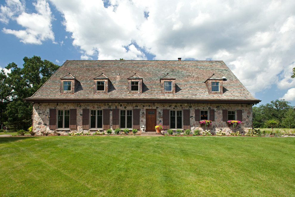 Example of a large french country two-story stone exterior home design in Minneapolis