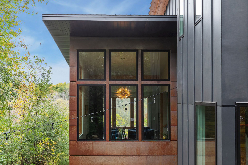 Zweistöckiges Rustikales Einfamilienhaus mit Metallfassade, blauer Fassadenfarbe, Pultdach und Blechdach in Minneapolis