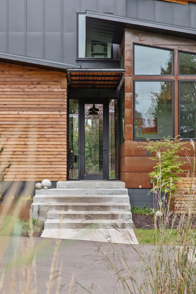Идея дизайна: двухэтажный, синий частный загородный дом в стиле рустика с облицовкой из металла, односкатной крышей и металлической крышей