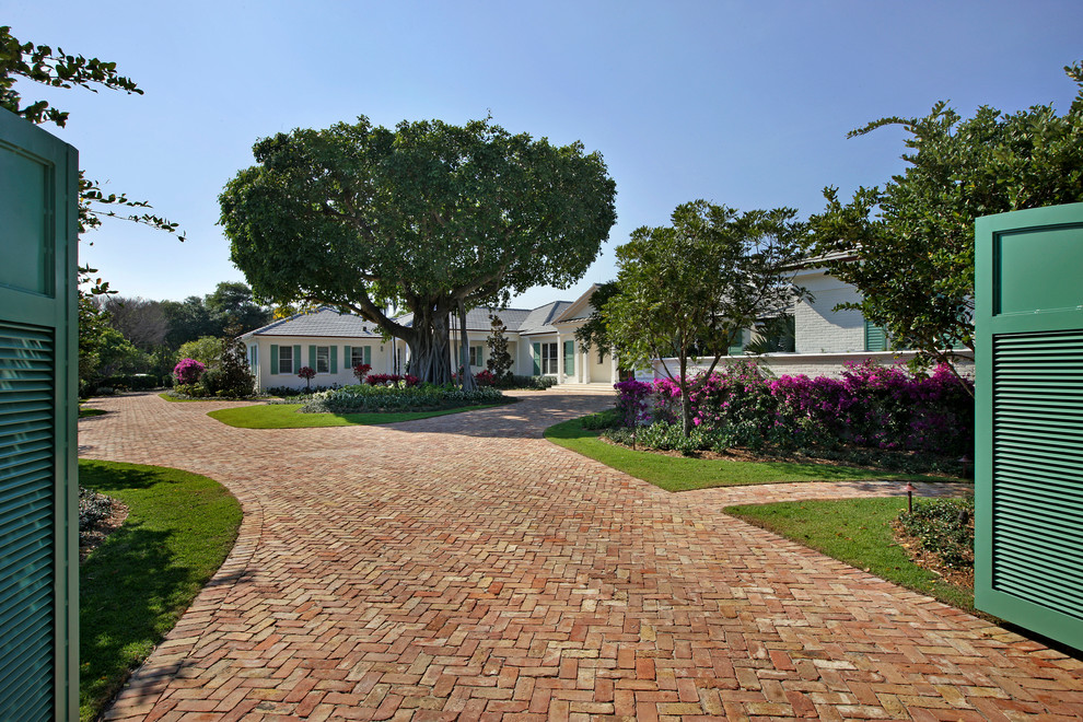 This is an example of an expansive and white traditional bungalow house exterior in Miami.