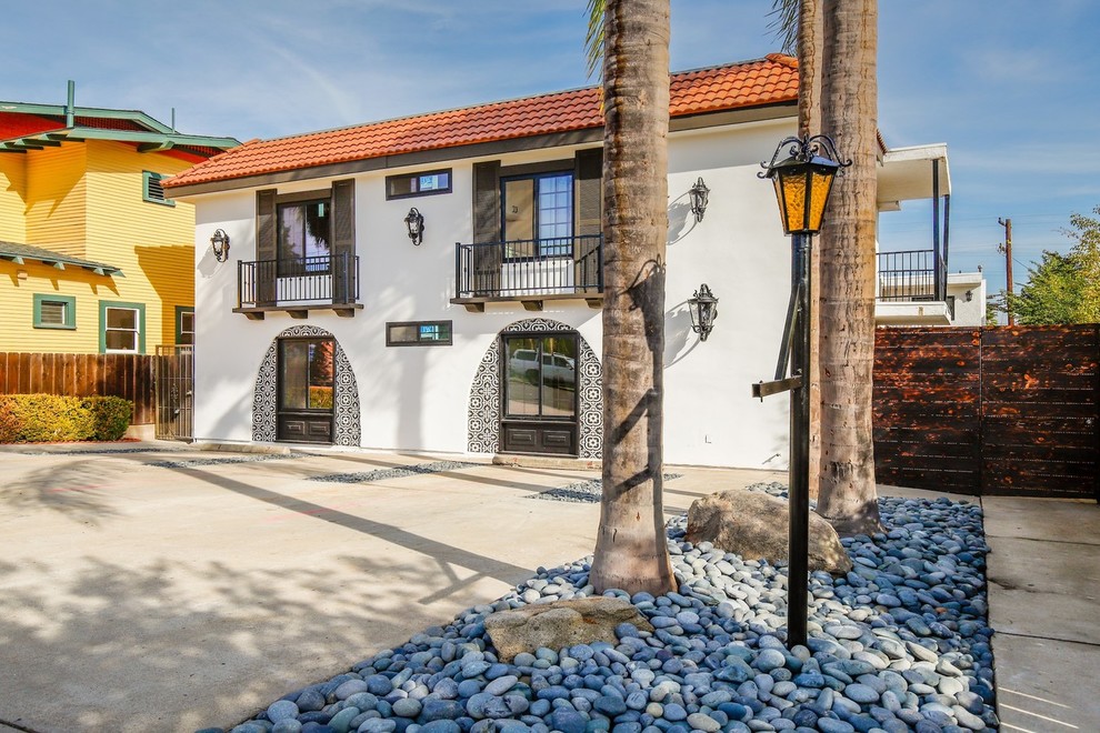 Kleines, Zweistöckiges Mediterranes Wohnung mit Lehmfassade, weißer Fassadenfarbe, Mansardendach und Ziegeldach in San Diego