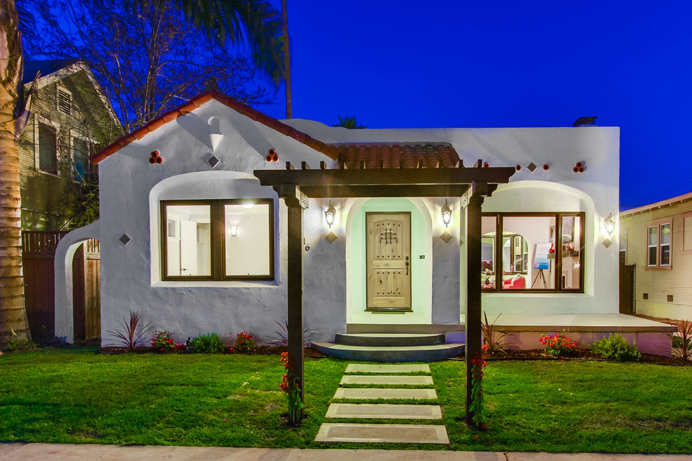 This is an example of a small and white mediterranean bungalow clay house exterior in San Diego.