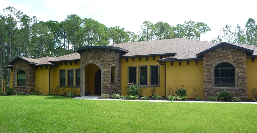 Inspiration for a large and yellow mediterranean bungalow detached house in Tampa with stone cladding, a hip roof and a shingle roof.