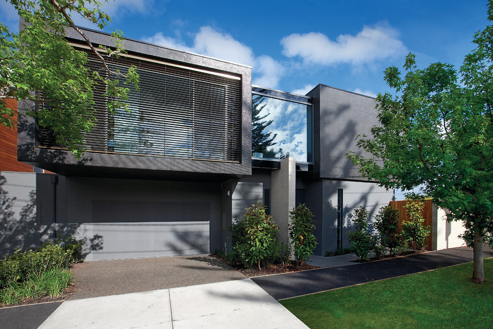 Aménagement d'une façade de maison métallique et noire moderne de taille moyenne et à un étage avec un toit plat.