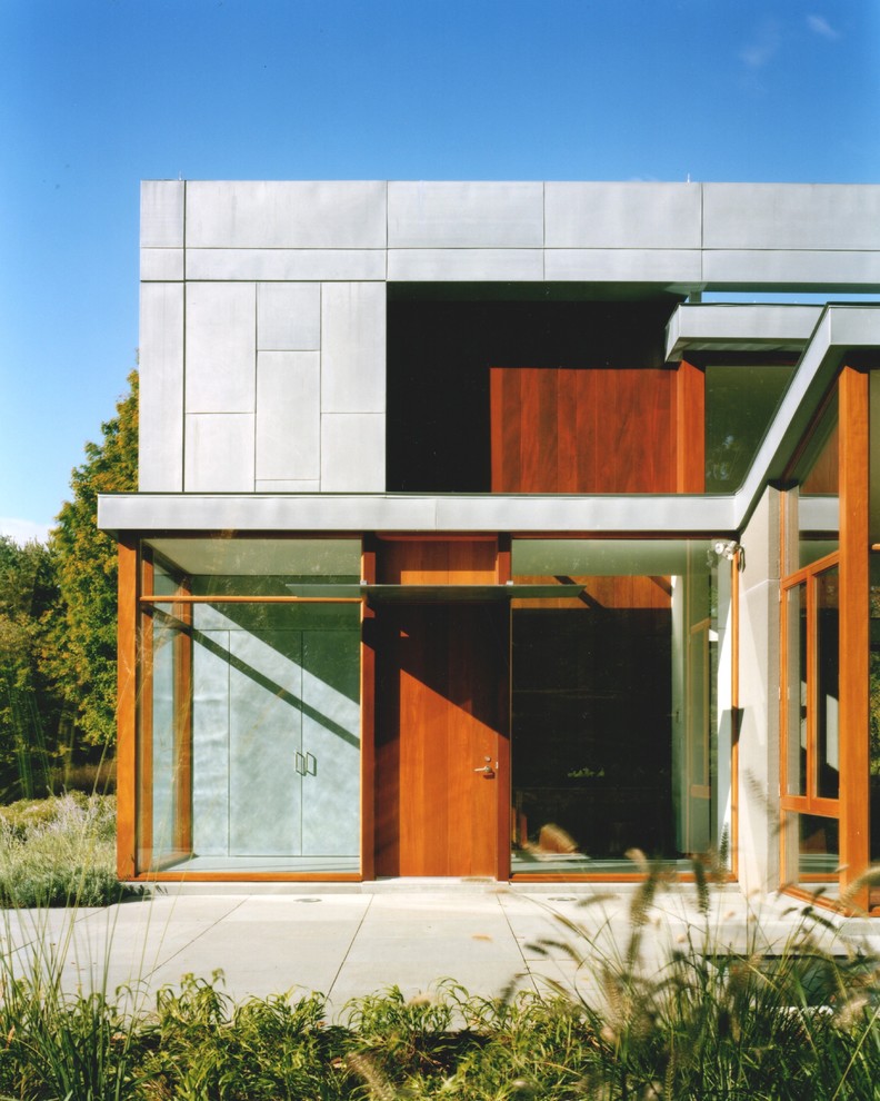 Imagen de fachada de casa gris minimalista grande de dos plantas con revestimientos combinados, tejado plano y tejado de teja de madera