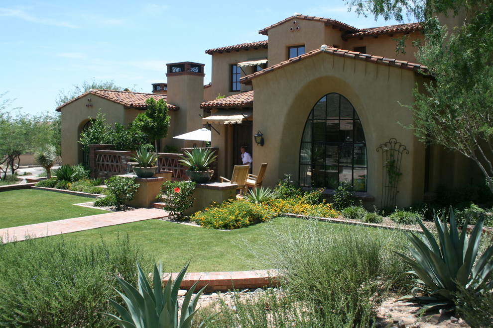 Example of a large tuscan beige two-story stucco exterior home design in Phoenix with a tile roof
