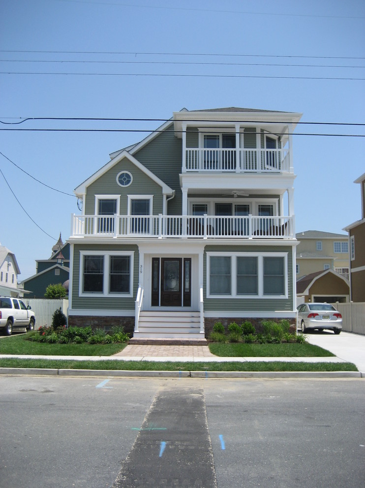 Photo of a green coastal house exterior in Philadelphia with three floors and vinyl cladding.