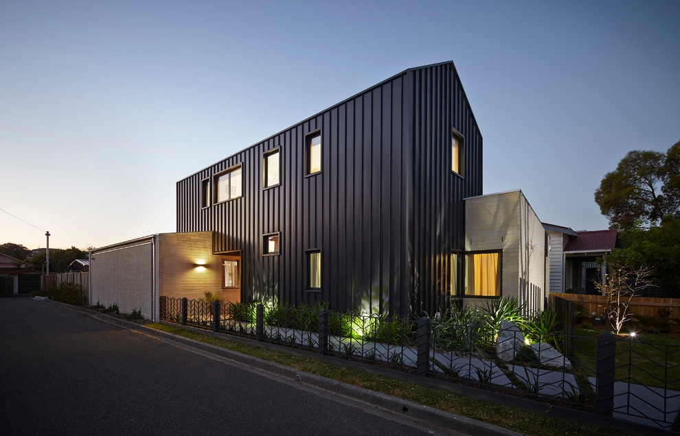 Idées déco pour une grande façade de maison métallique et noire contemporaine à un étage.